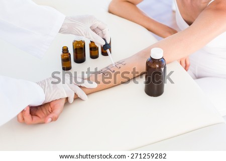 Doctor doing skin prick test at her patient in medical office