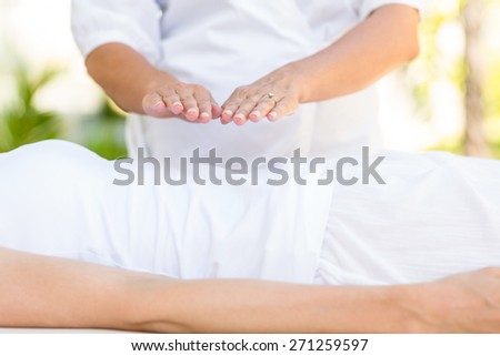 Calm woman receiving reiki treatment in the health spa