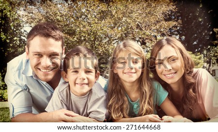Happy family lying on the grass smiling at camera in park