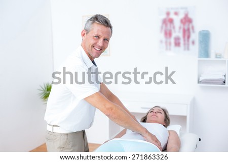 Physiotherapist doing stomach massage to his patient in medical office