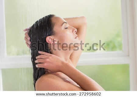 Pretty brunette taking a shower in a bathroom