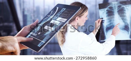 Man using tablet pc against room with large window looking on city