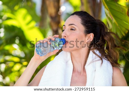Beautiful brunette drinking water on a sunny day