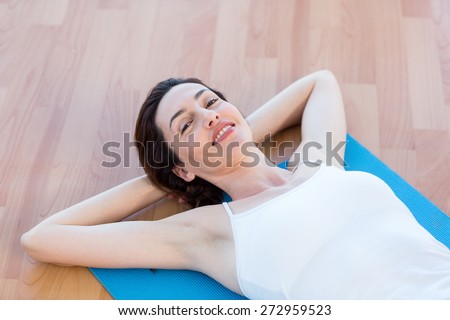 Smiling woman lying on exercise mat in medical office