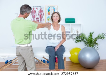 Doctor stretching his patients arm in medical office
