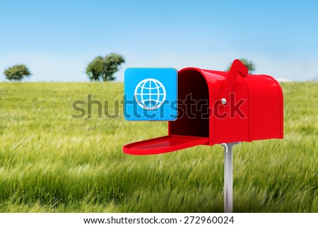 Red email postbox against green meadow