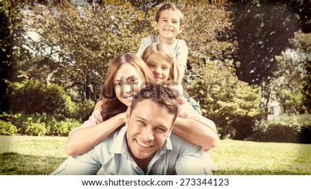 Happy family members lying on each other in the park smiling at camera