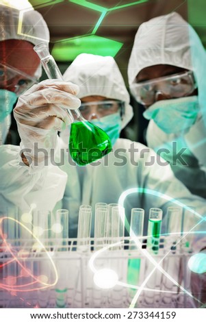 Science and medical graphic against chemists in protective suits looking at green liquid in beaker Chemists in protective suits looking at green liquid in beaker in the lab