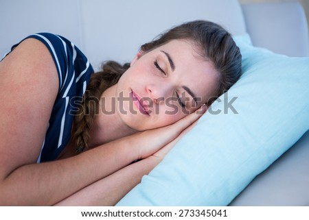 Peaceful woman sleeping on couch at home in the living room