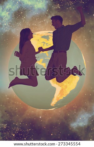 Cheerful young couple jumping against starry night sky