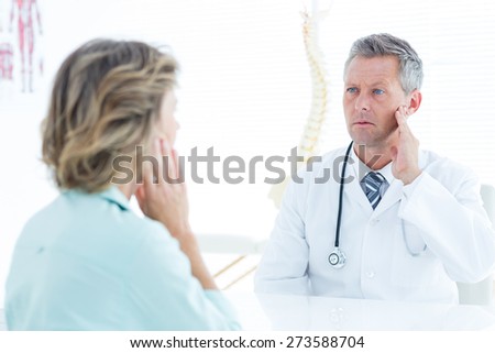 Doctor touching his jaw in medical office