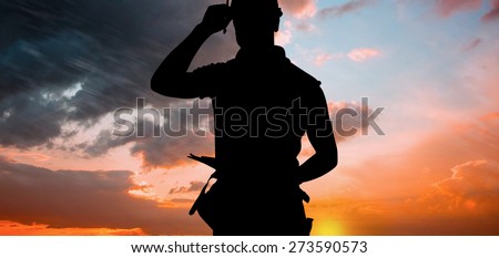 Portrait of smiling manual worker holding clipboard against orange and blue sky with clouds
