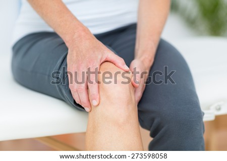 Woman having knee pain in medical office