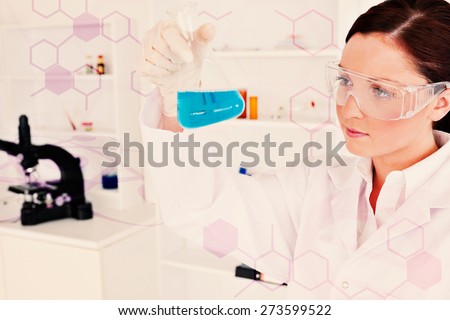 Science and medical graphic against cute female scientist looking at a beaker in a lab