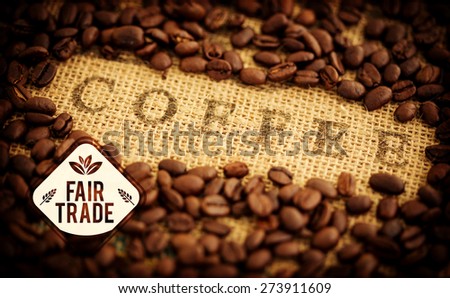 Fair Trade graphic against coffee beans surrounding coffee stamped on sack