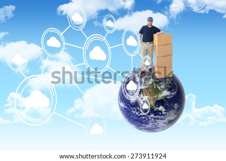 Happy delivery man with cardboard boxes against blue sky