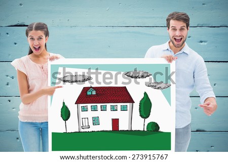Attractive young couple smiling at camera holding poster against painted blue wooden planks