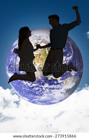 Cheerful young couple jumping against night sky