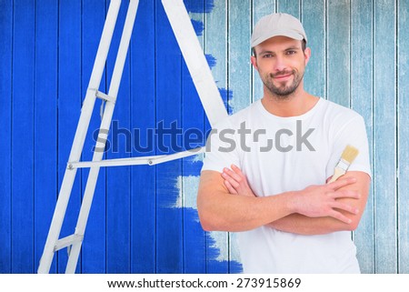 handyman with paintbrush and ladder against wooden planks