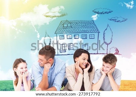 Family lying with head in hands against blue sky over green field