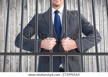 Businessman holding his hands out against digitally generated grey wooden planks