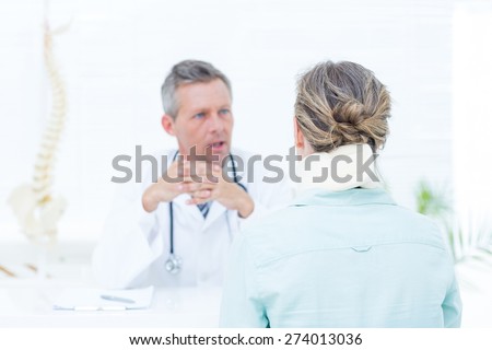 Doctor having conversation with his patient in medical office