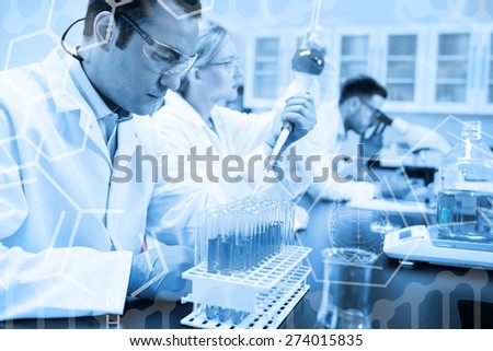 Science graphic against science student using pipette in the lab to fill test tubes