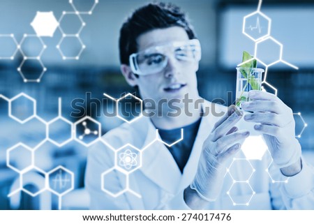 Science graphic against student standing at the laboratory looking at the beaker