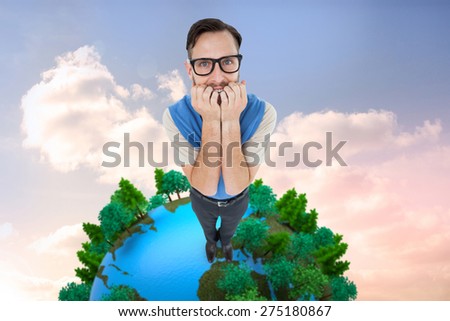 Geeky hipster looking nervously at camera against beautiful blue cloudy sky