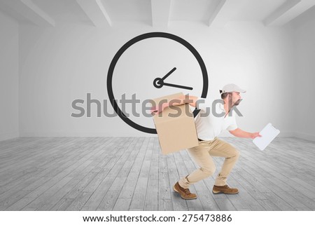 Delivery man with cardboard box against big room with white wall