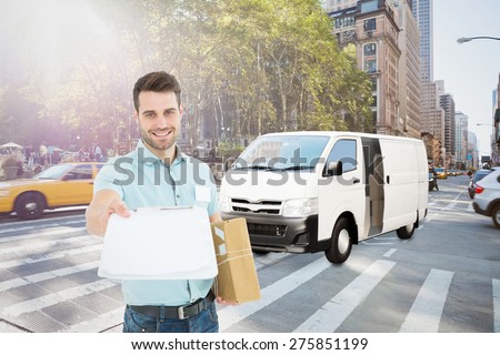 Delivery man with package giving clipboard for signature against new york street