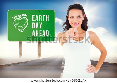 Pretty brunette pointing with finger against open road