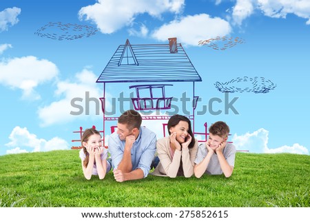 Family lying with head in hands against blue sky over green field