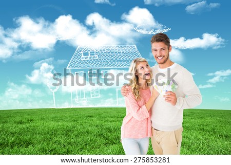 Attractive couple flashing their cash against blue sky over green field