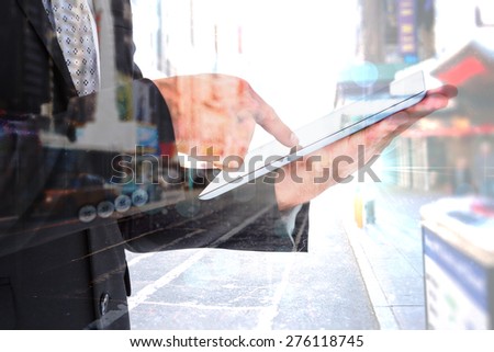 Businessman using his tablet pc against blurry new york street