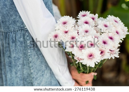 Pretty blonde woman holding bunch of flowers in the park