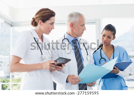 Doctors working together on patients file in medical office