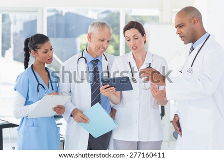 Team of doctors working together on patients file in medical office
