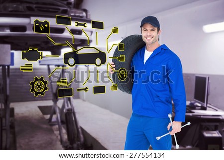 Confident mechanic carrying tire against auto repair shop