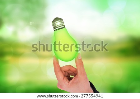 Businessman measuring something with his fingers against green abstract light spot design