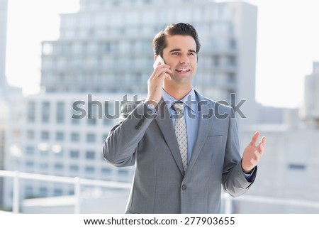 Smiling businessman talking on the phone at the patio