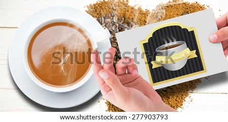 Hand showing card against coffee in heart shape