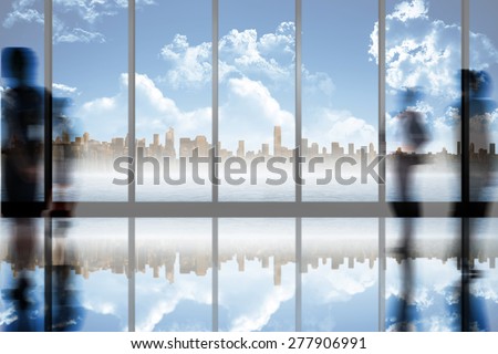 Silhouettes of business people against room with large window looking on city skyline