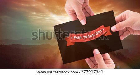 Hand showing card against sunrise over mountains