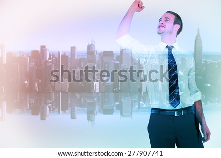 Businessman cheering with clenched fist against mirror image of city skyline