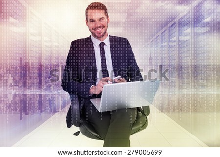 Happy businessman with laptop using smartphone against digitally generated server room with towers