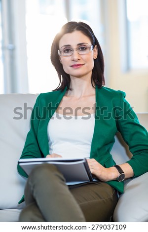 Psychologist sitting on the couch and looking at camera in the office