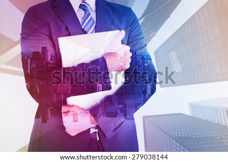 Businessman holding his laptop tightly against mirror image of city skyline