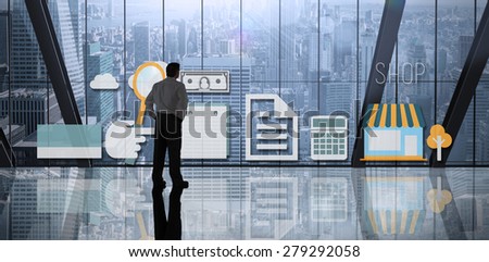 Businessman standing against room with large window looking on city