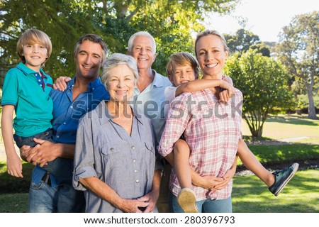 Happy family smiling at the camera on a sunny day